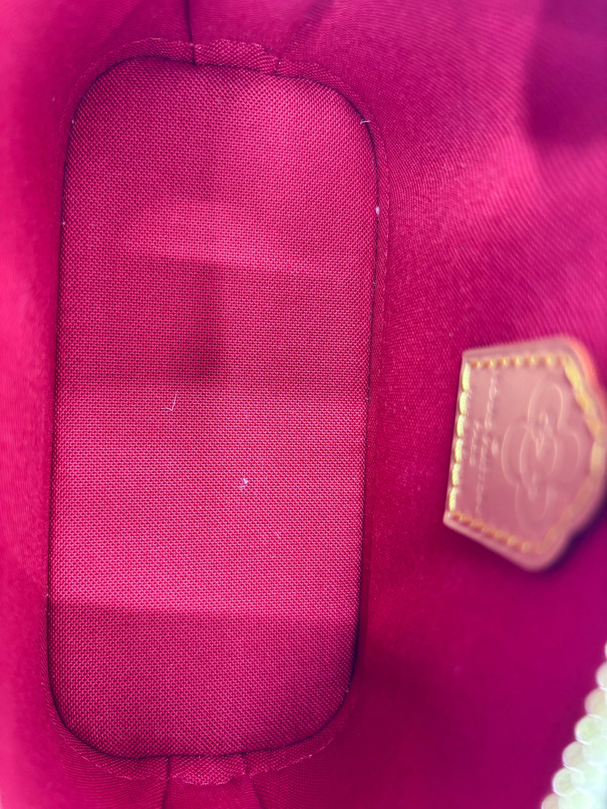 Interior of Posh Purse Co Louis Vuitton Nano Alma 2024 Christmas Edition bag with vibrant red fabric lining