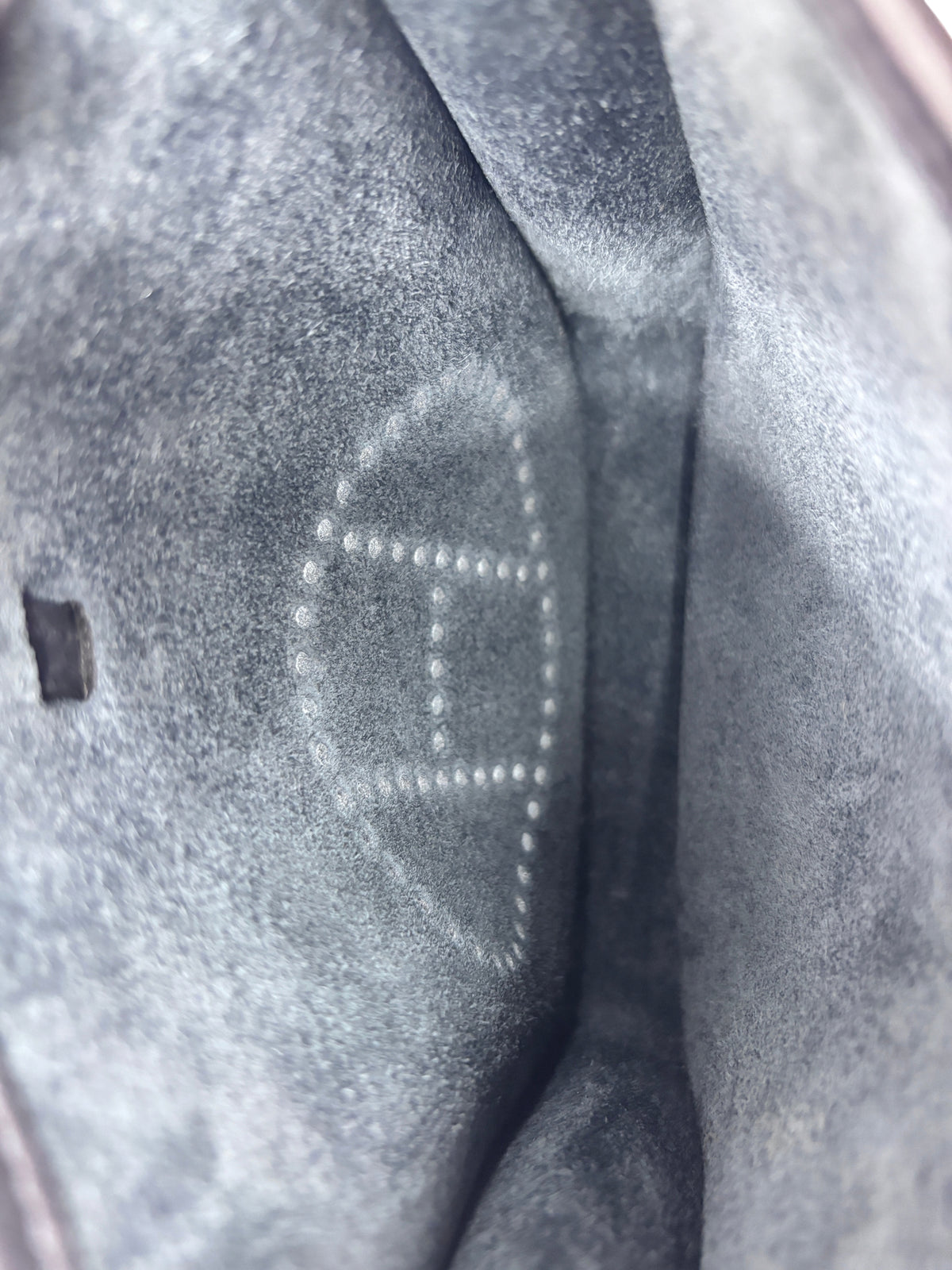 Interior of Posh Purse Co. Hermès Evelyne TPM bag showing the signature perforated H logo on the suede lining