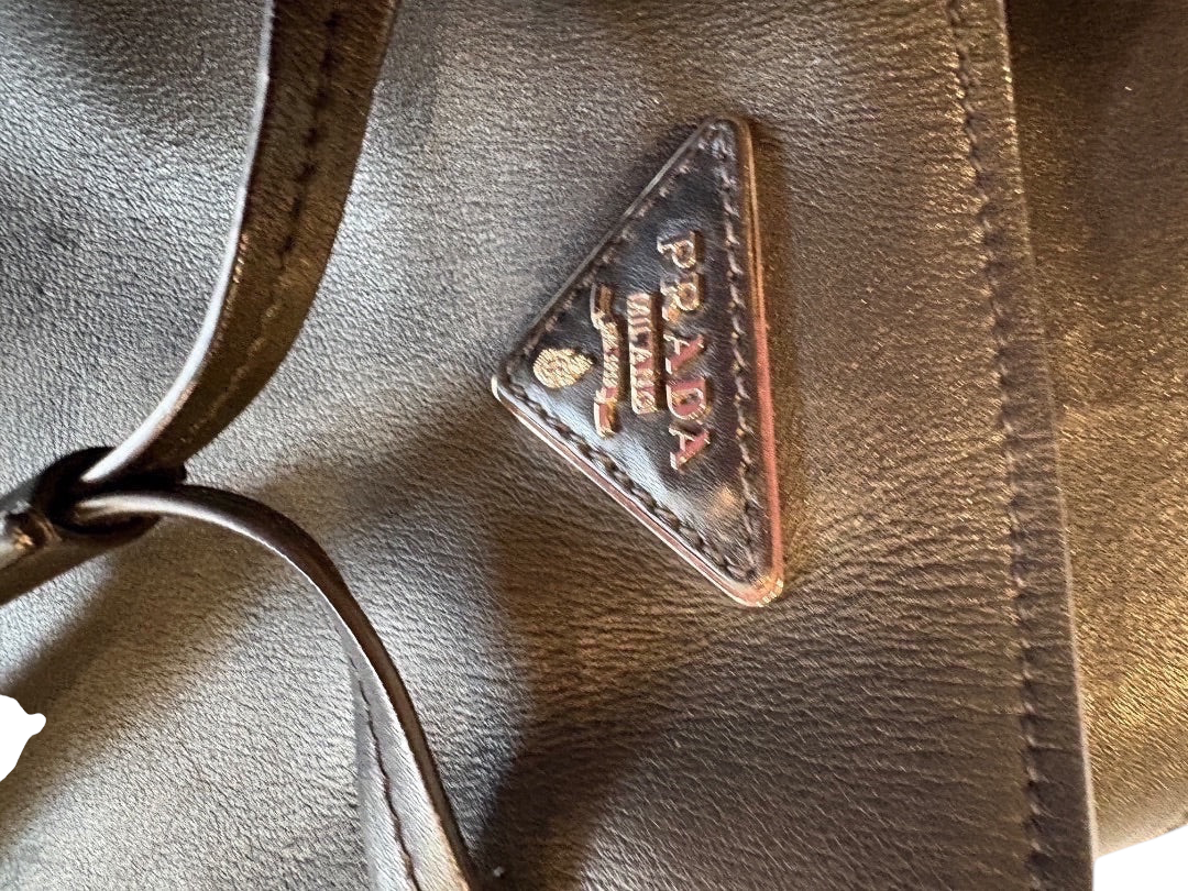 Posh Purse Co. black Prada leather bucket bag with iconic triangular logo and shoulder strap.