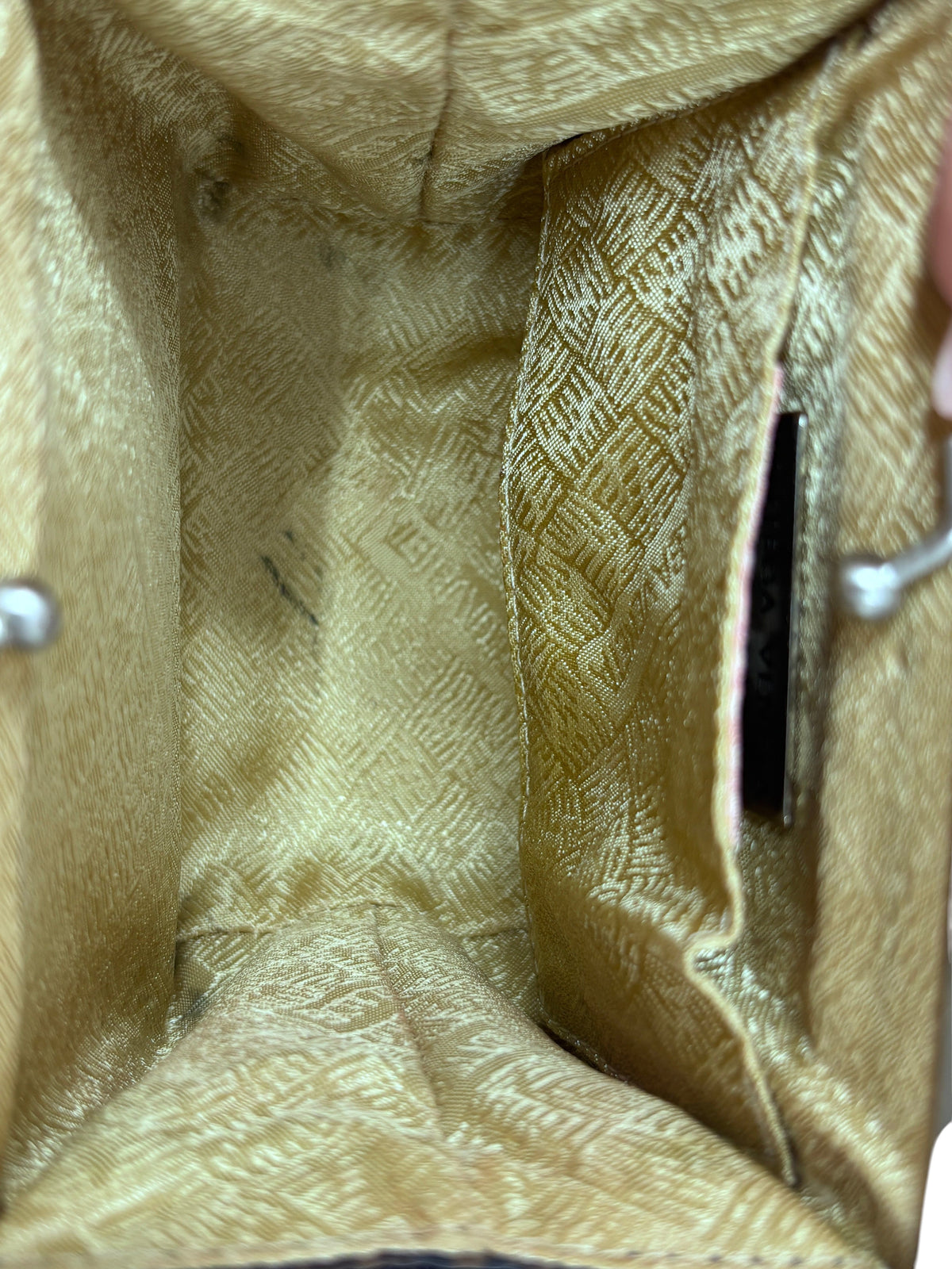 Interior of a Posh Purse Co vintage Bottega box-frame bag featuring gold patterned lining and a small side pocket.