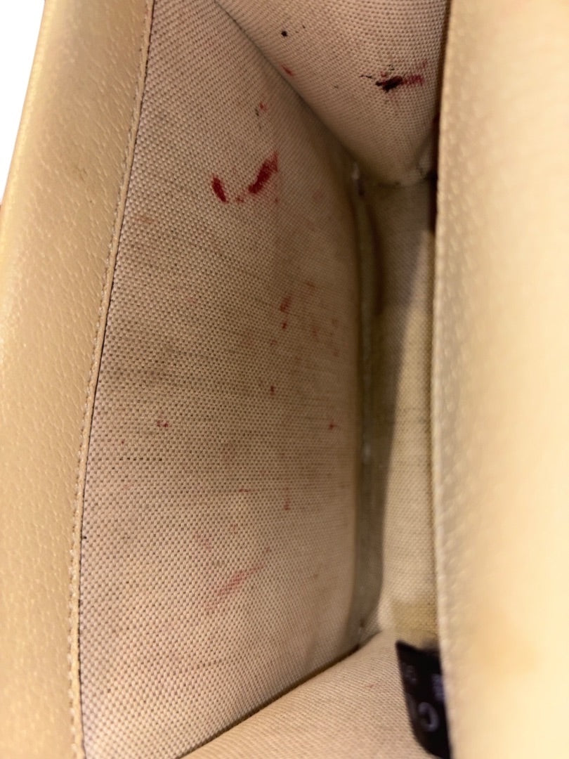 Interior of Posh Purse Co. cream leather Gucci Dionysus bag with red stains on the fabric lining.