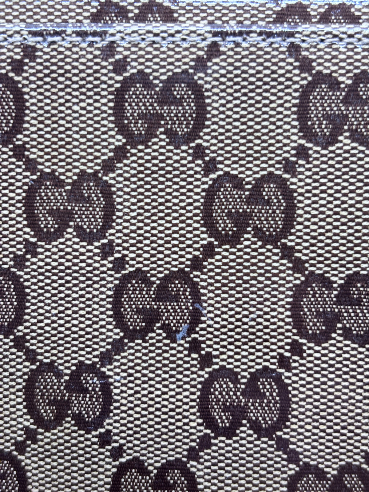 Close-up of the iconic brown and beige GG monogram canvas pattern on a vintage Posh Purse Co. Gucci Gifford tote.