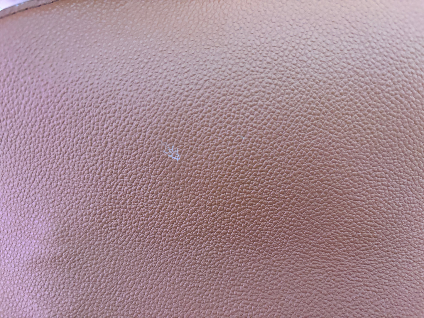 Close-up of brown leather texture on a Posh Purse Co. Louis Vuitton Pochette Metis showing a small surface mark