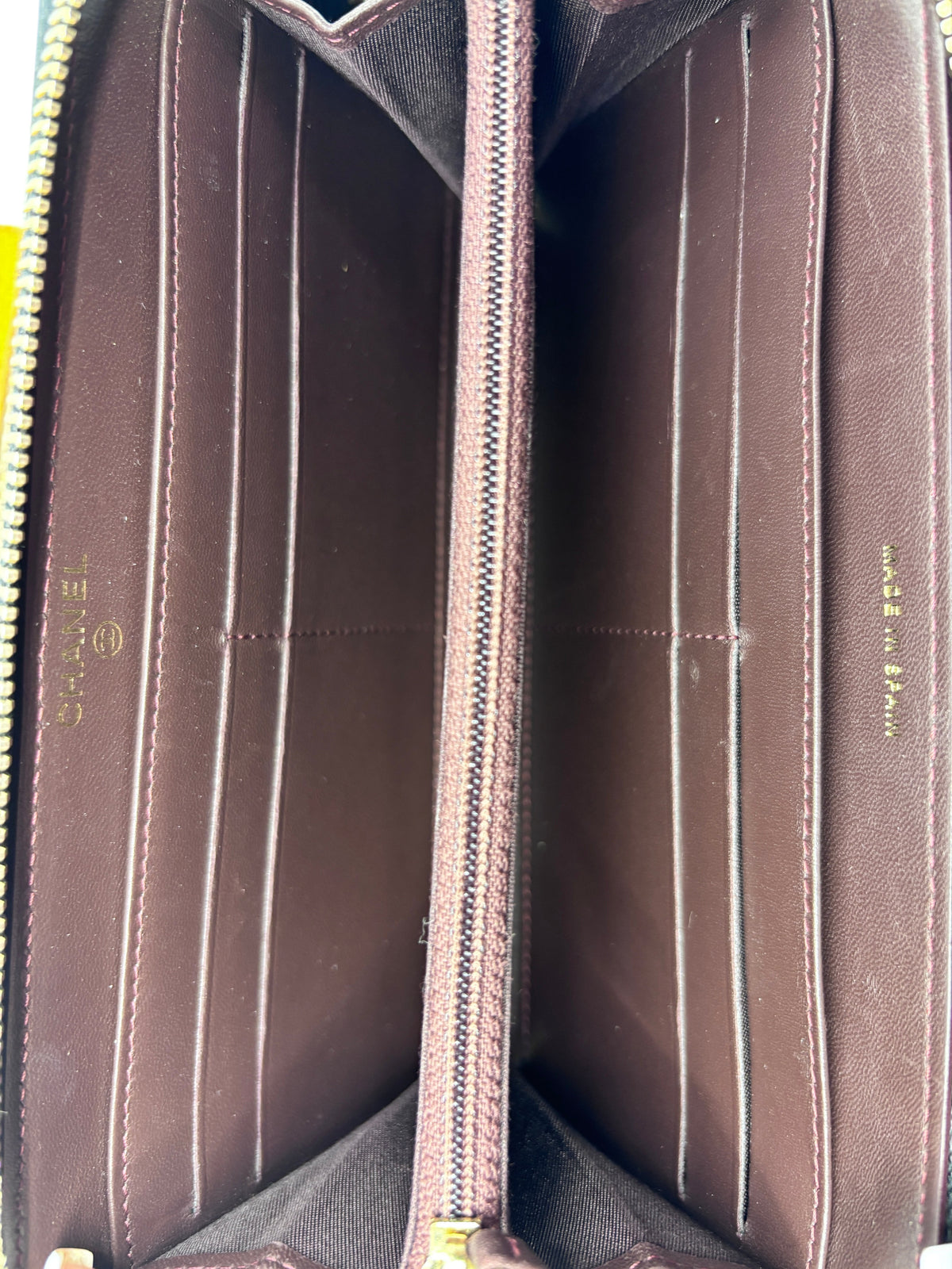 Interior of a preloved Posh Purse Co. Chanel Continental wallet featuring dark brown leather and gold hardware.