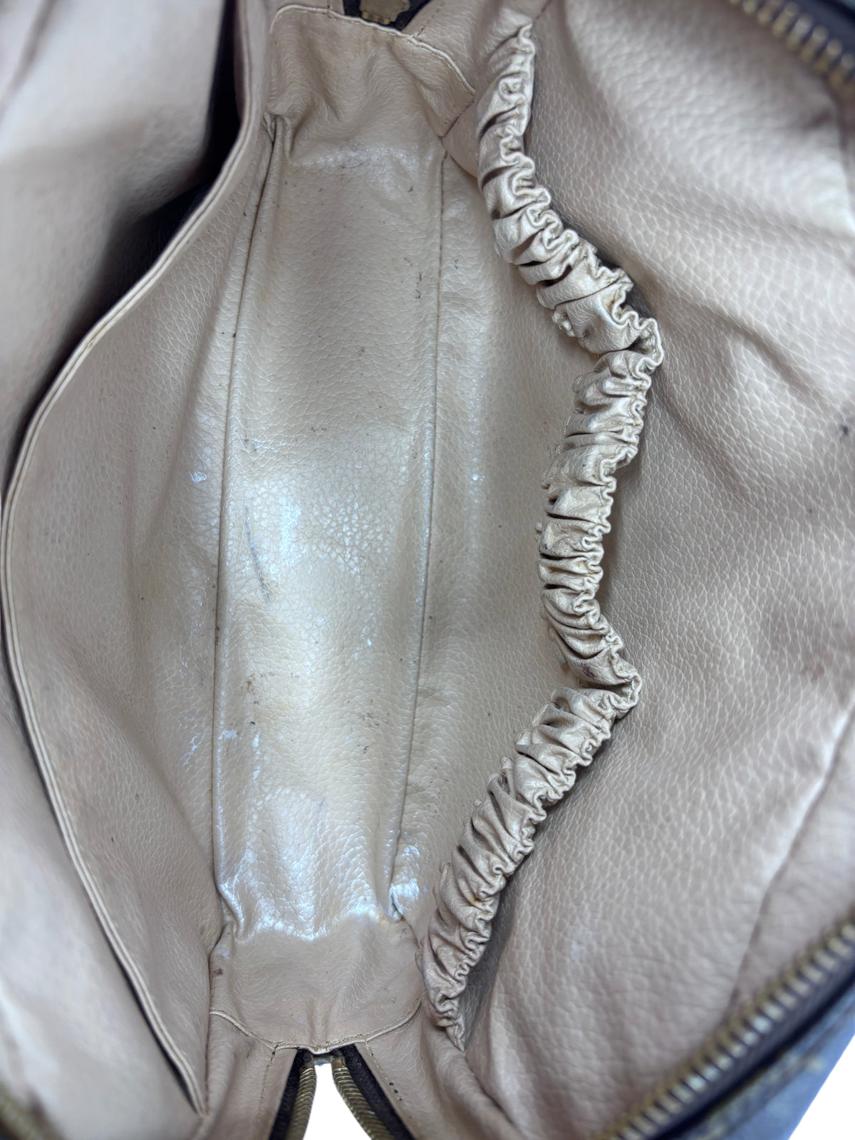 Interior of a preloved Posh Purse Co. Louis Vuitton Trousse Toilette 23 showing beige lining and elasticated pocket