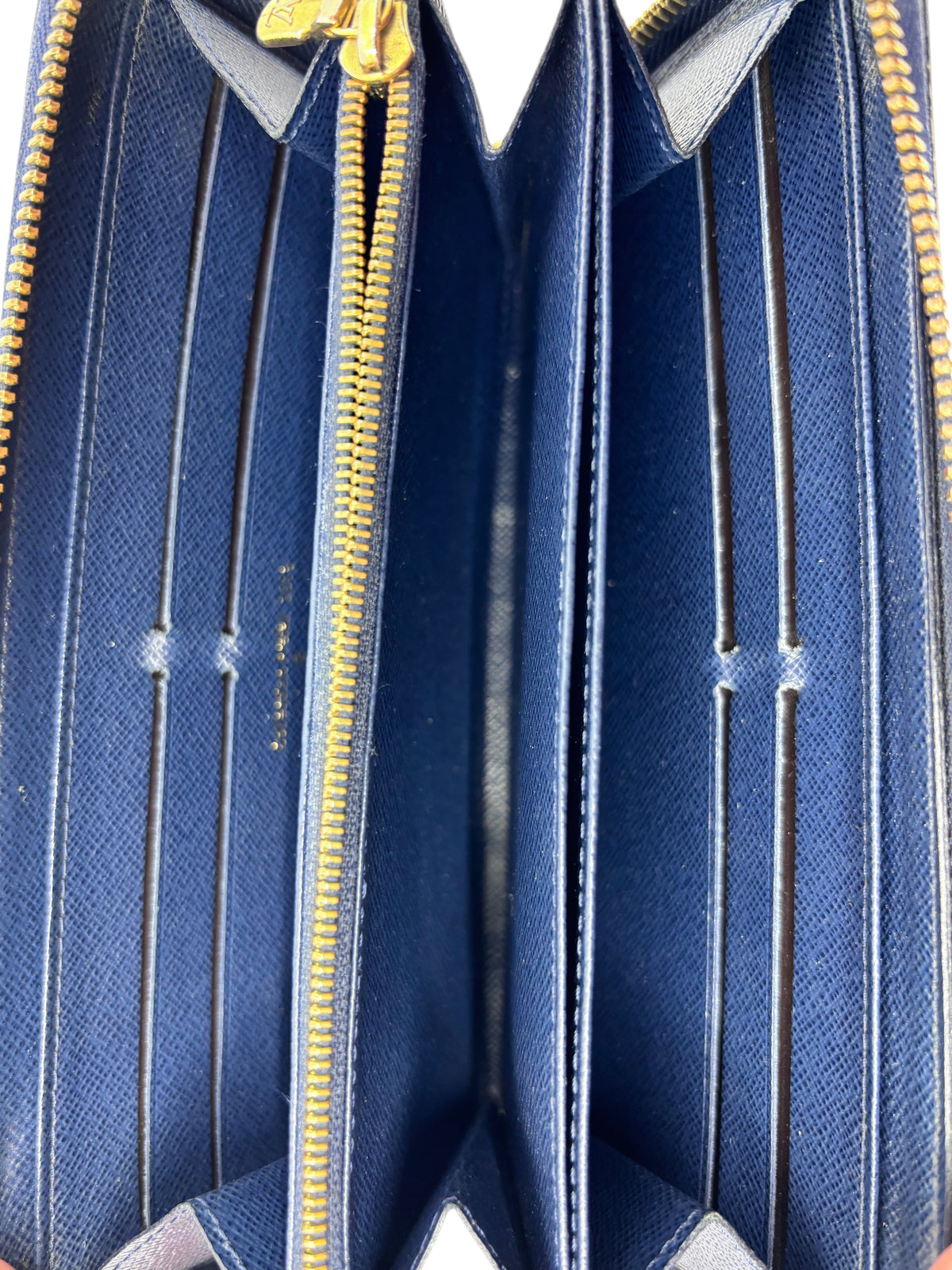 Interior view of a blue Louis Vuitton Zippy wallet with gold-tone zipper and multiple card slots by Posh Purse Co