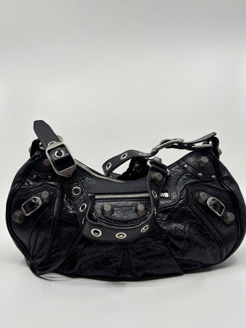 Posh Purse Co. black leather Balenciaga La Cagole shoulder bag with silver studs and buckle details.