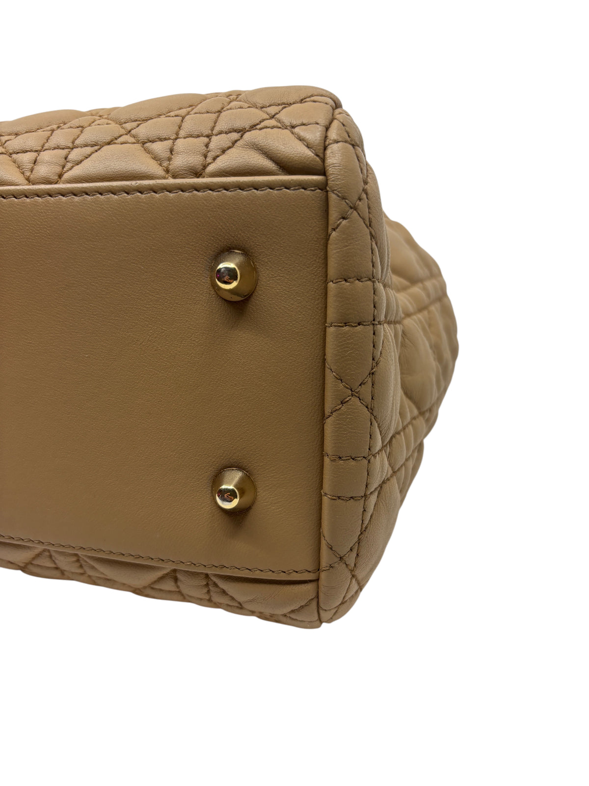 Posh Purse Co. beige Dior Cannage tote bag base showing protective gold-tone metal feet and quilted leather detail.