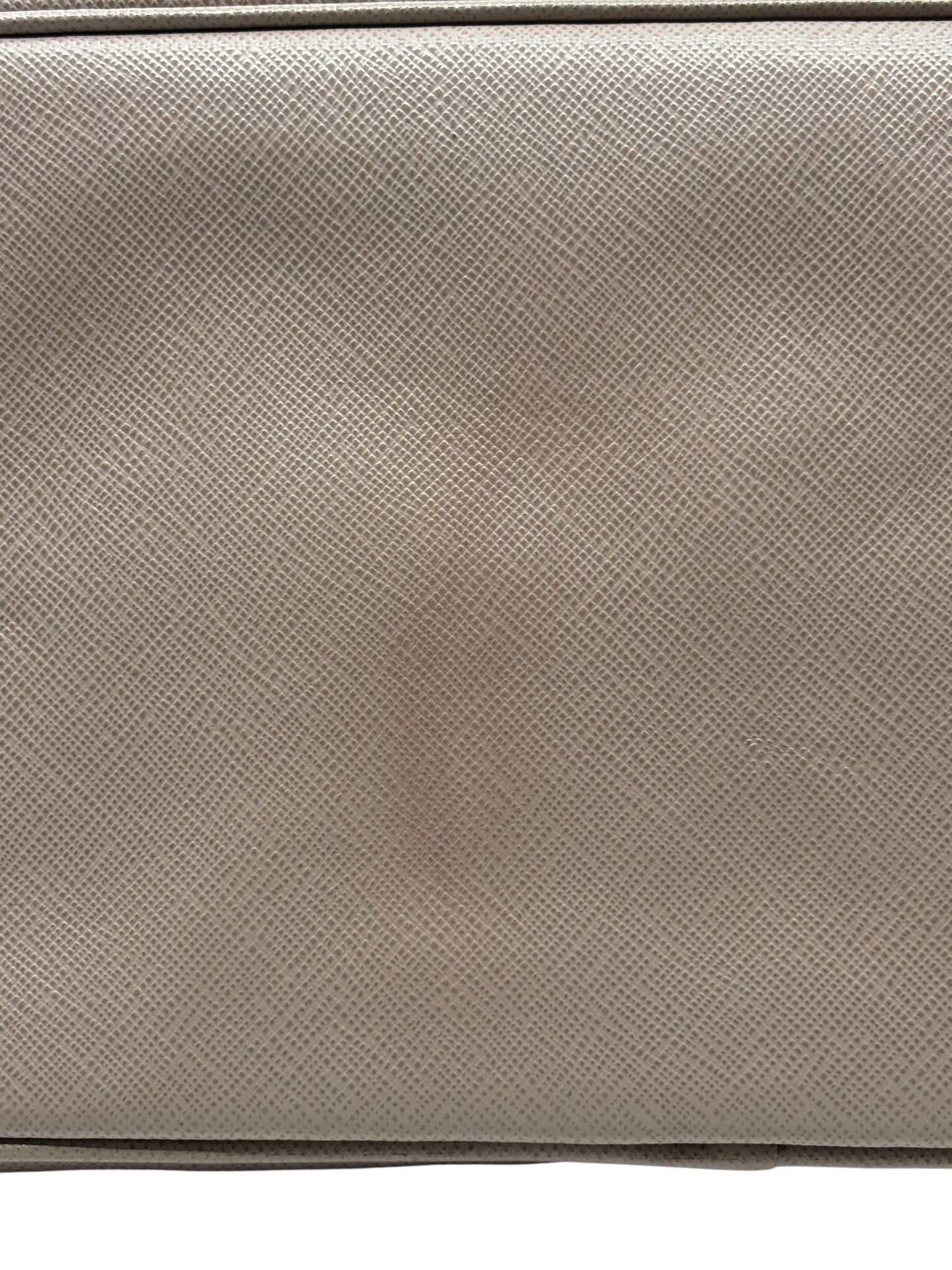 Close-up of beige Saffiano leather texture on a Posh Purse Co. Prada tote bag showing signature crosshatch pattern.