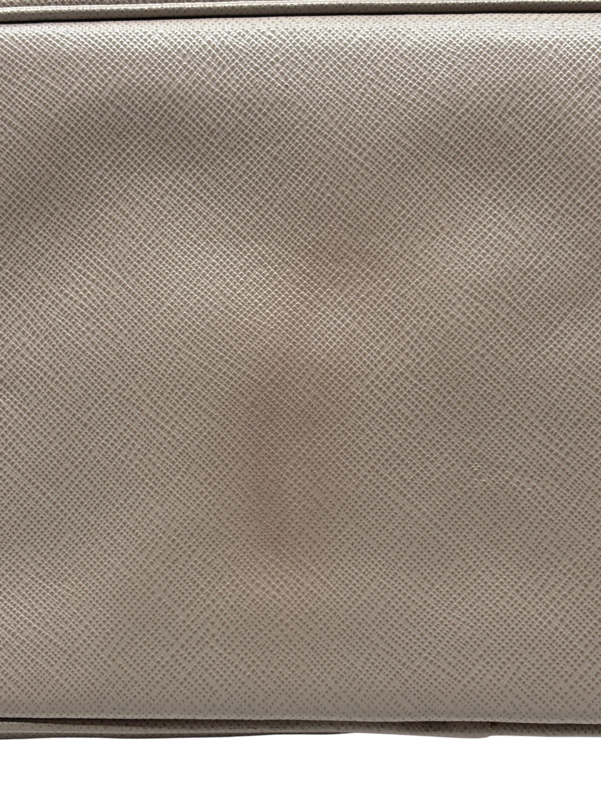 Close-up of beige Saffiano leather texture on a Posh Purse Co. Prada tote bag showing signature crosshatch pattern.