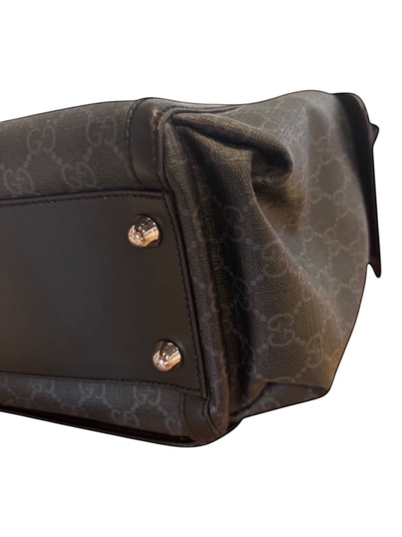 Posh Purse Co black canvas messenger bag with signature pattern and leather trim, featuring silver hardware and metal feet.