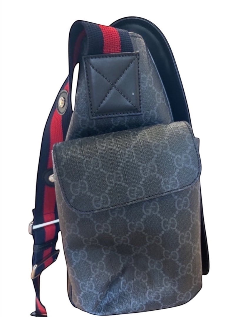 Posh Purse Co black canvas messenger bag with signature pattern, red and blue striped strap, and leather trim.