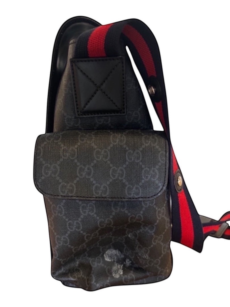 Posh Purse Co black canvas messenger bag with signature pattern, red and blue striped adjustable strap, and leather trim.