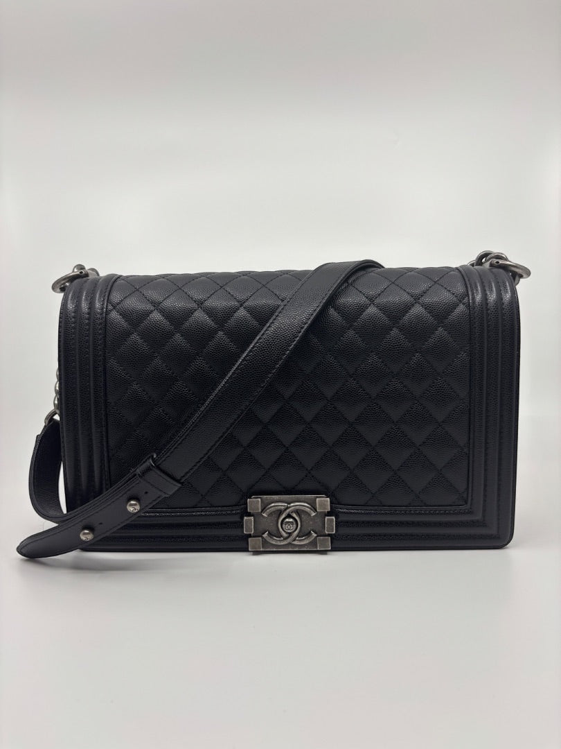 Posh Purse Co. large black Chanel Boy Bag in caviar leather with signature quilting and chain strap.