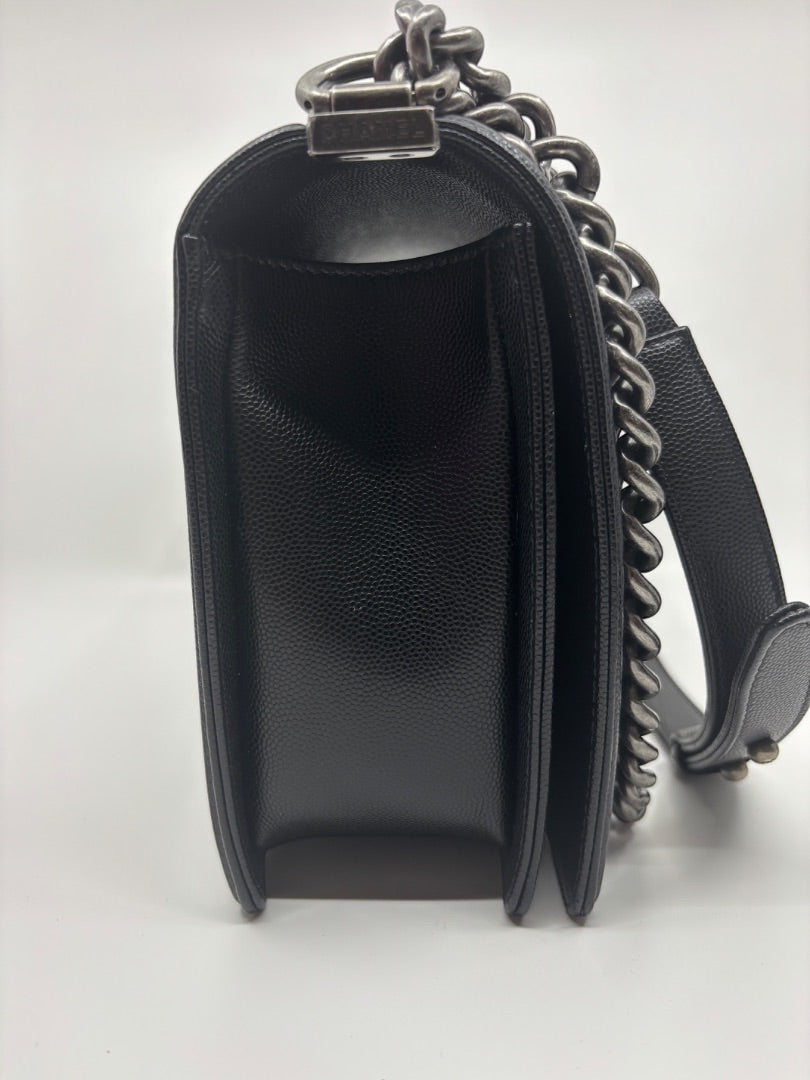 Posh Purse Co. large black Chanel Boy Bag in caviar leather with signature chain strap and structured silhouette.