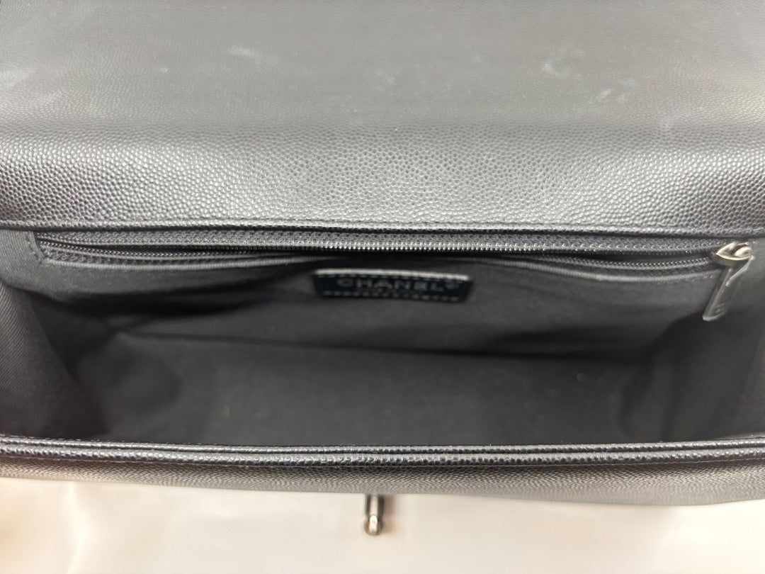 Posh Purse Co. Black Chanel Boy Bag, large size, crafted from caviar leather with a structured silhouette and signature chain strap. Interior view showing zipper pocket.