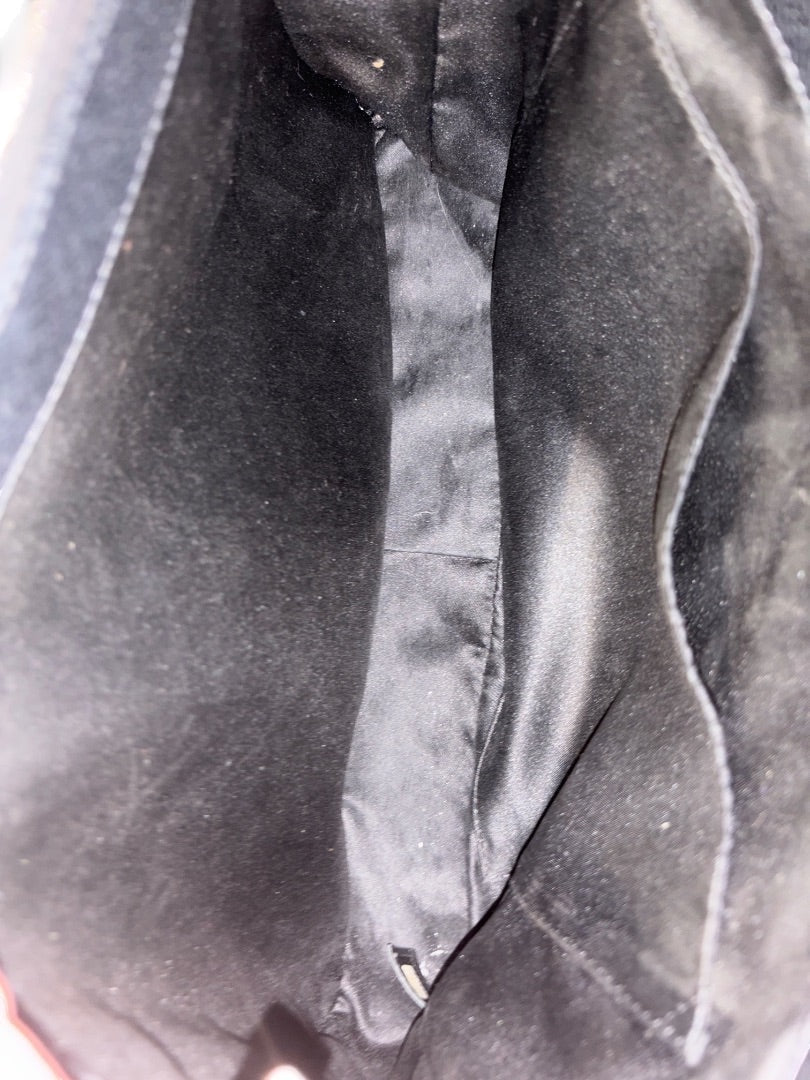 Interior of a black Chanel Grand Shopping Tote (GST) made of caviar leather with silver-tone hardware and multiple compartments.