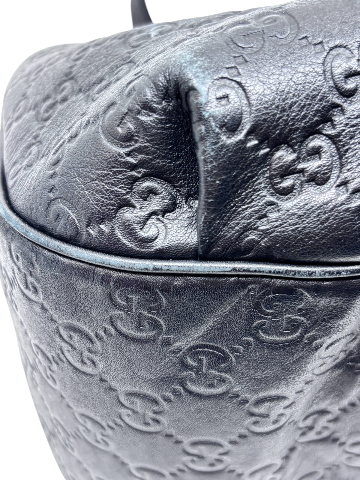 Close-up of Posh Purse Co. preloved black leather Gucci Horsebit 1955 hobo bag with embossed GG monogram pattern.