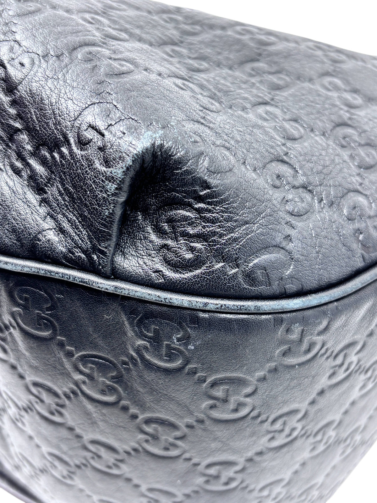 Close-up of black embossed leather on a Posh Purse Co. Gucci Horsebit 1955 hobo bag showing texture and corner detail.