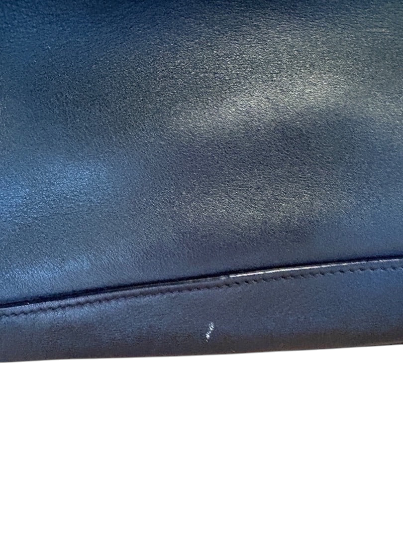 Posh Purse Co. black Prada leather bucket bag with subtle scuff mark on bottom edge.