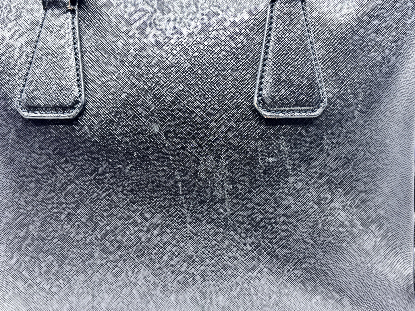 Posh Purse Co black Prada Saffiano leather briefcase showing surface wear and marks on the textured exterior
