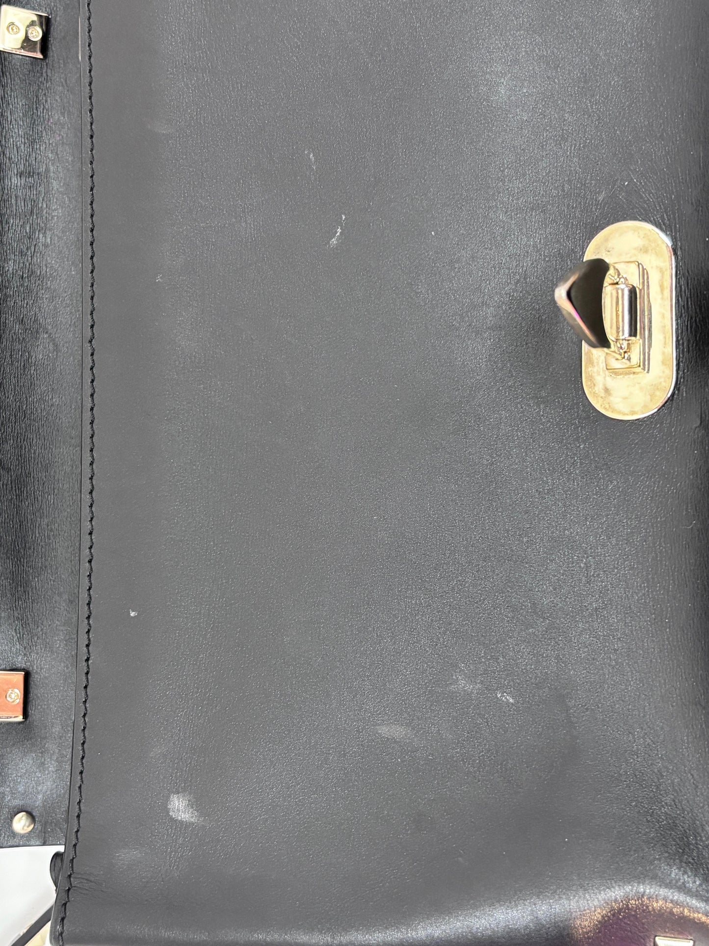 Posh Purse Co. preloved black Valentino Rockstud flap bag featuring a gold flip-lock closure and leather texture.
