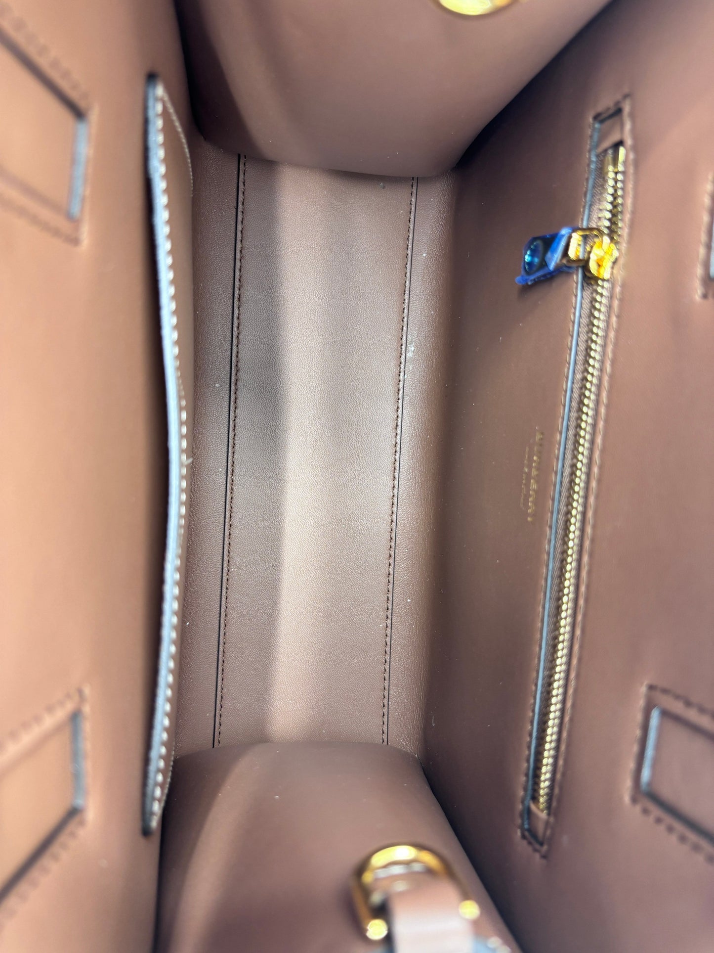 Interior of a brown leather Burberry Mini Frances Tote from Posh Purse Co with a gold zipper pocket and clean lining