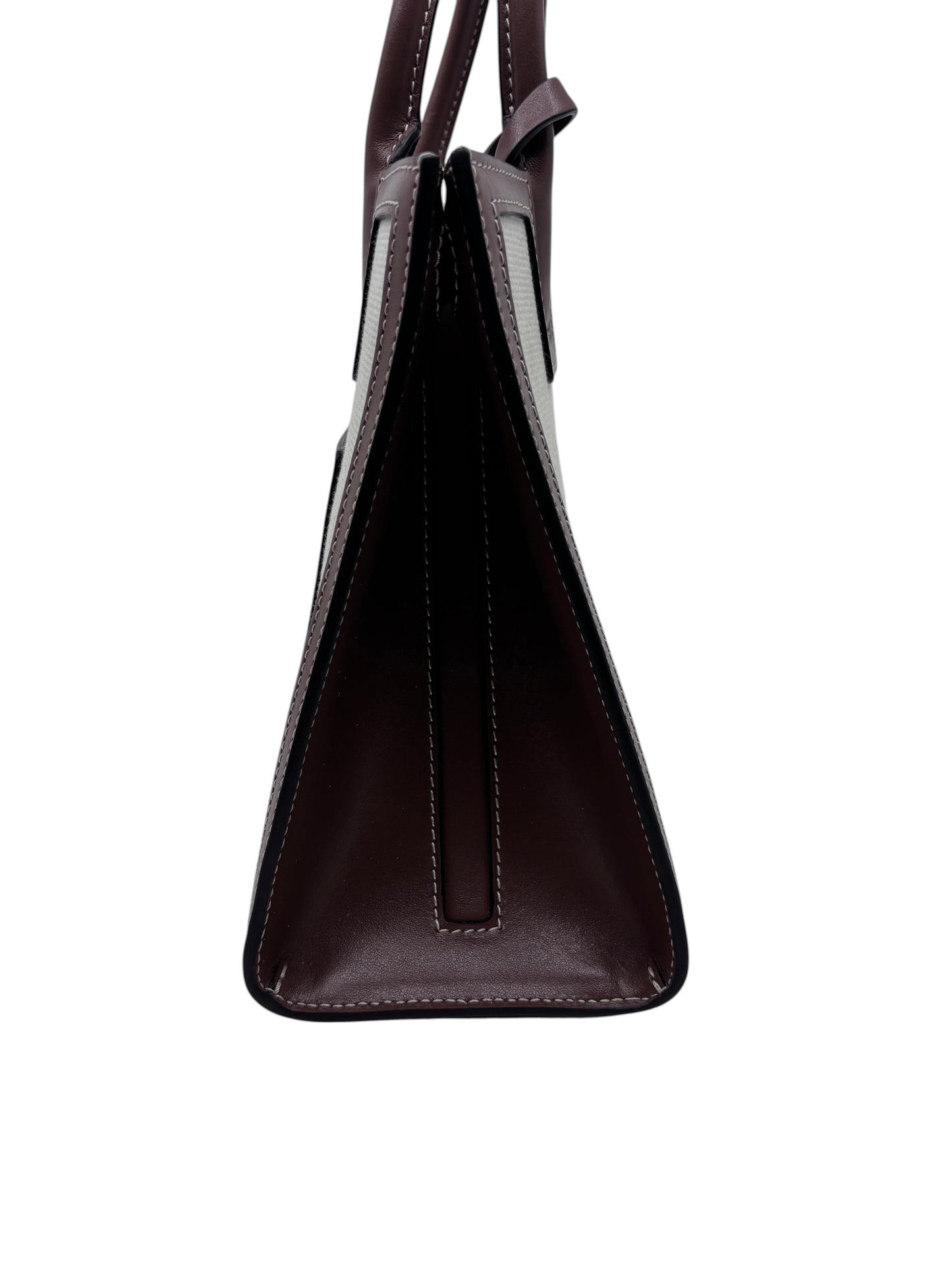 Side profile of a Posh Purse Co preloved Burberry Mini Frances tote in dark burgundy leather with white stitching.