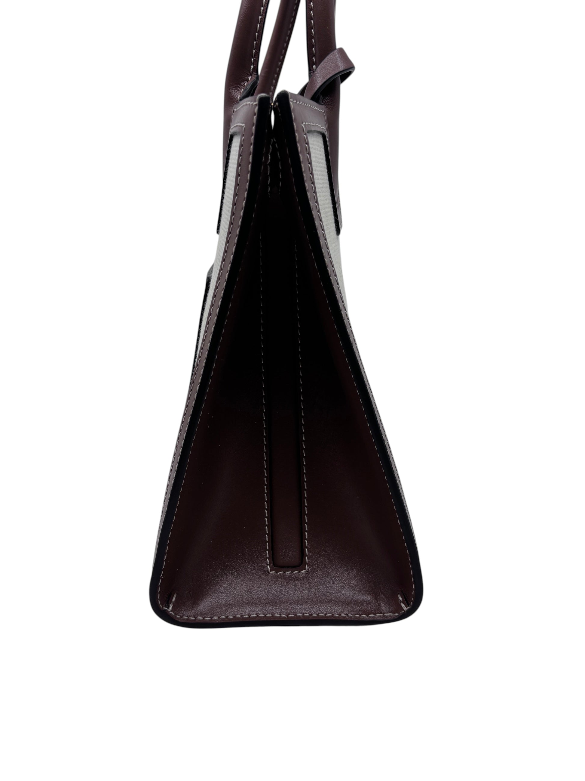 Side profile of a Posh Purse Co preloved Burberry Mini Frances tote in dark burgundy leather with white stitching.