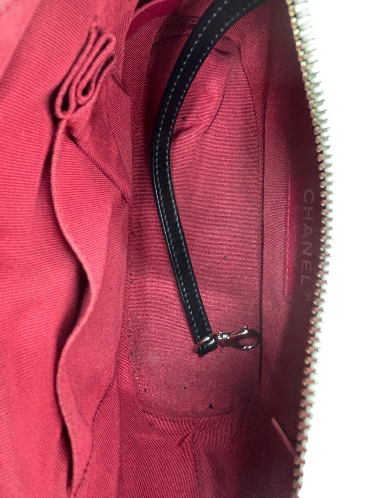 Interior of a Posh Purse Co preloved Chanel Gabrielle bag with red fabric lining, leather key strap, and Chanel logo tag.