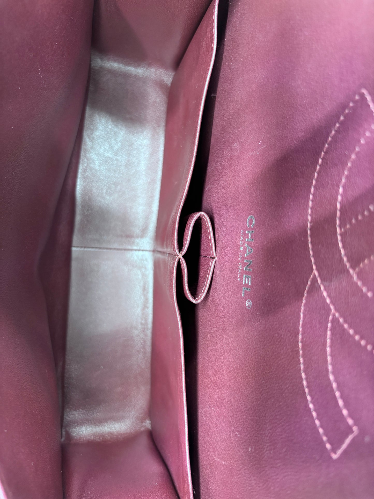 Interior of Posh Purse Co Chanel Classic Jumbo Flap bag featuring burgundy leather lining and embossed logo