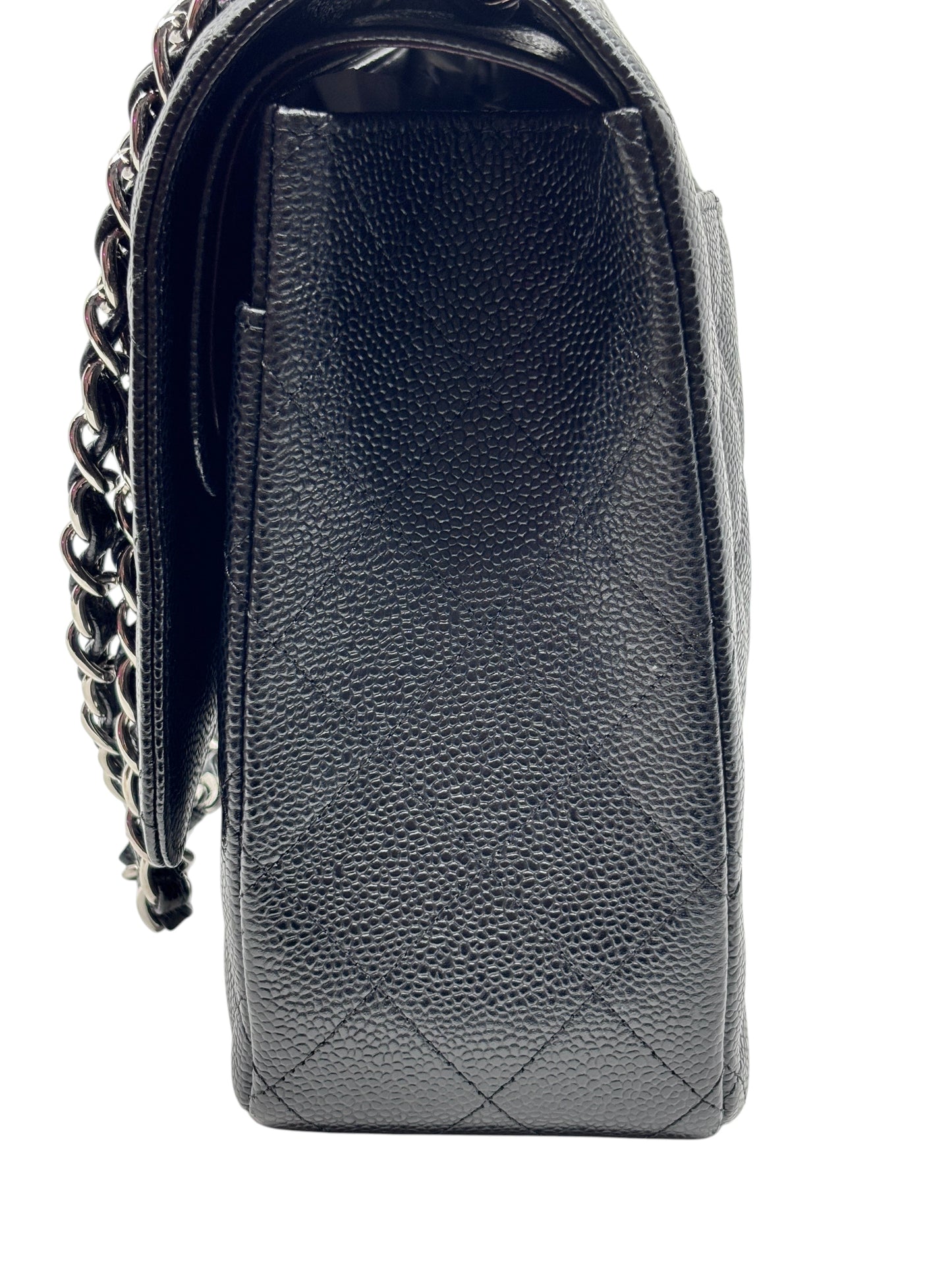 Side view of a black quilted caviar leather Chanel Jumbo Classic Flap bag with silver chain strap from Posh Purse Co