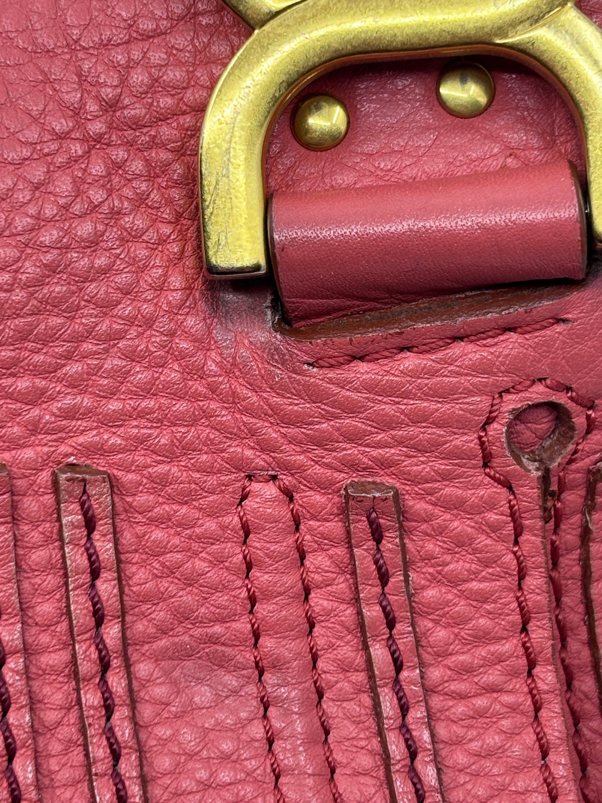 Posh Purse Co. Chloé Marcie satchel detail showing coral pebbled leather, signature curved stitching, and gold hardware