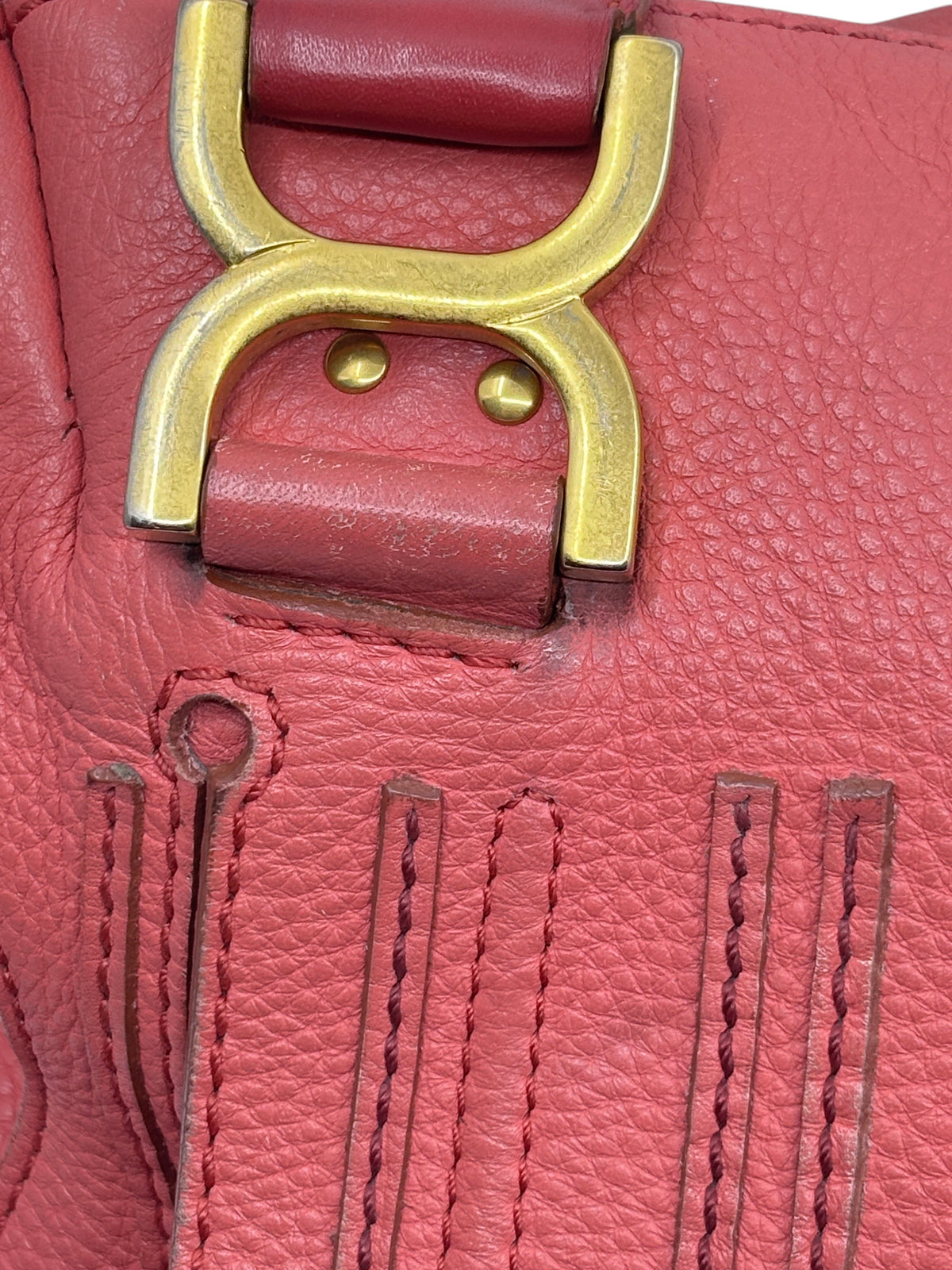 Close-up of Posh Purse Co. preowned Chloé Marcie satchel in coral leather with signature gold hardware and stitching
