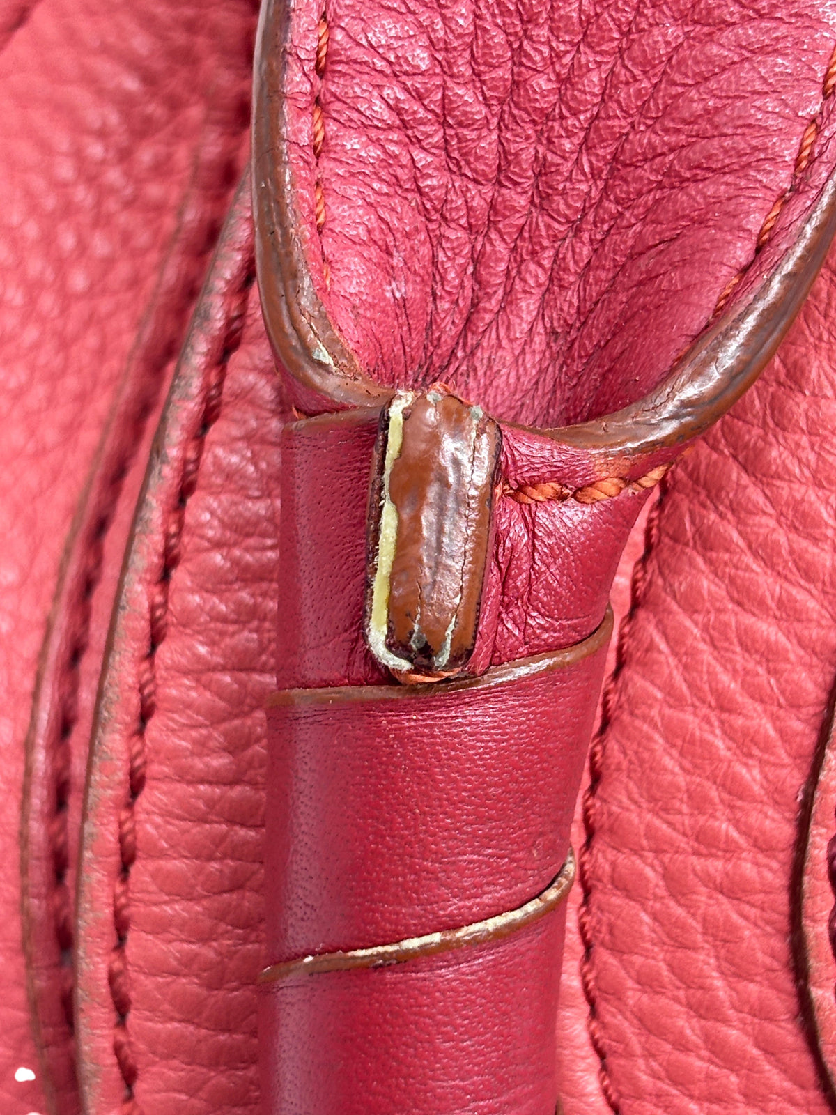 Close-up of Posh Purse Co. preowned Chloé Marcie satchel showing coral leather texture and handle stitching detail.