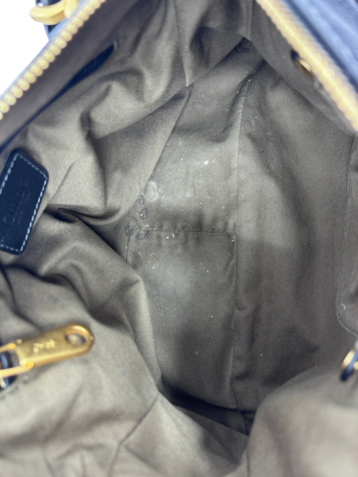 Interior of Posh Purse Co. preloved black Chloé Marcie medium satchel bag showing fabric lining and gold hardware