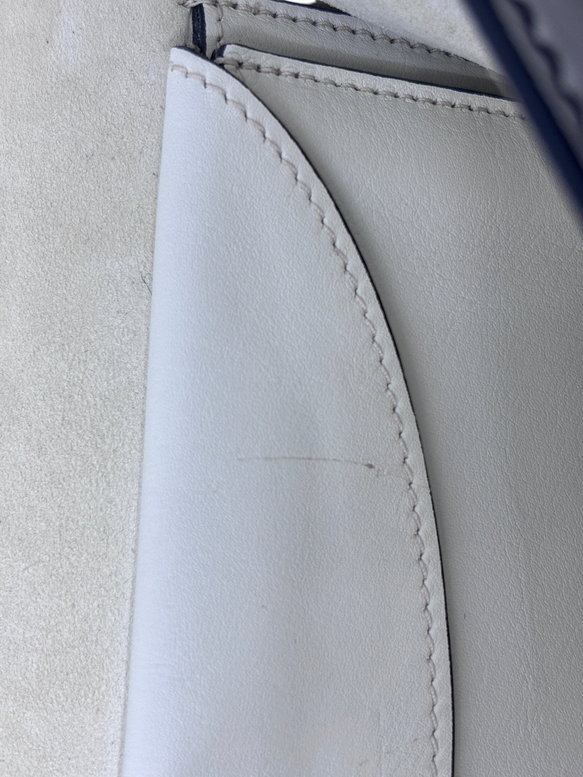 Close-up of the interior lining of a Posh Purse Co ivory Dior J'Adior bag showing a minor scratch on the leather.