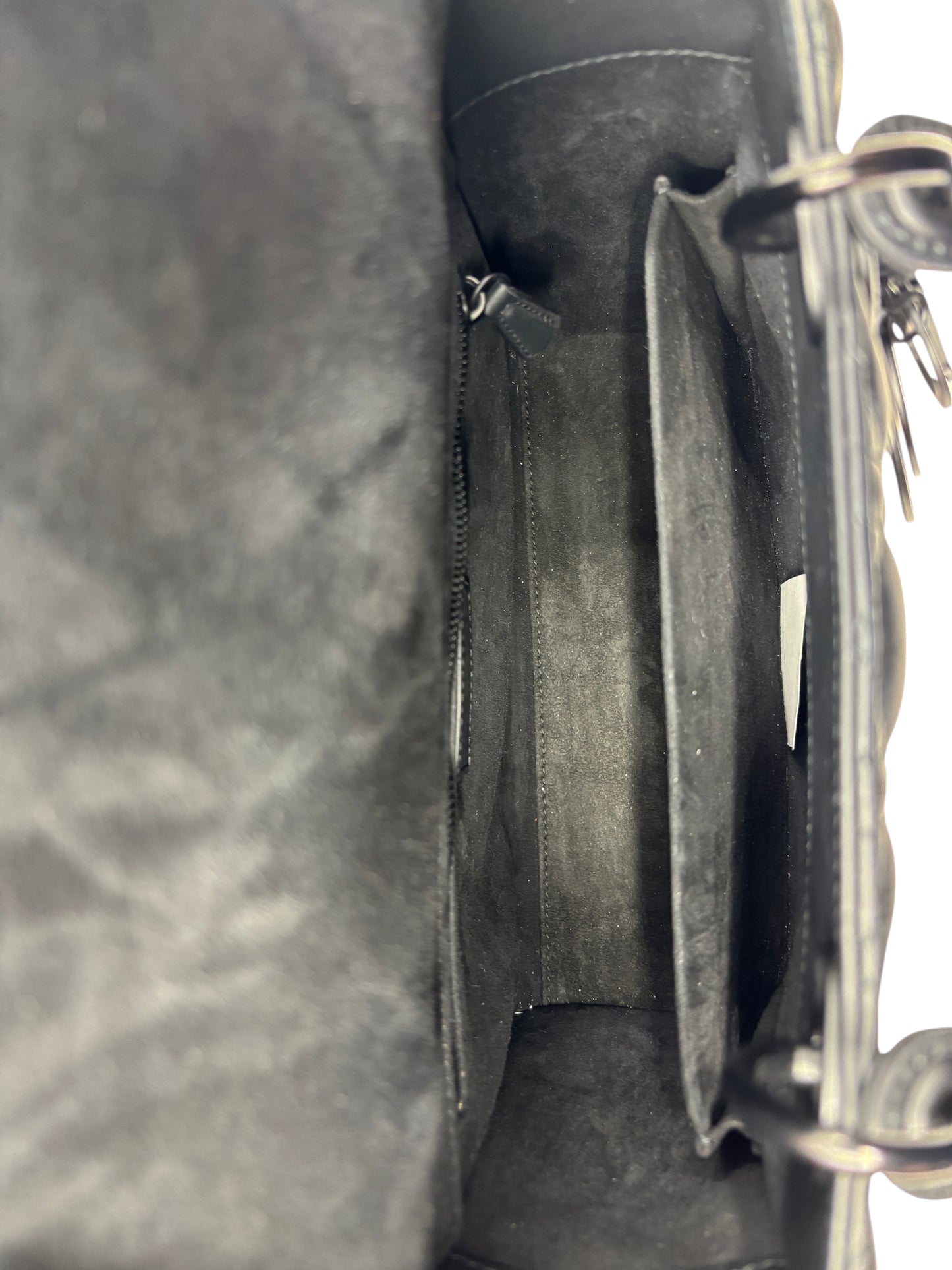 Interior view of a Posh Purse Co. preloved Dior Lady Dior medium bag featuring a spacious matte black suede lining.