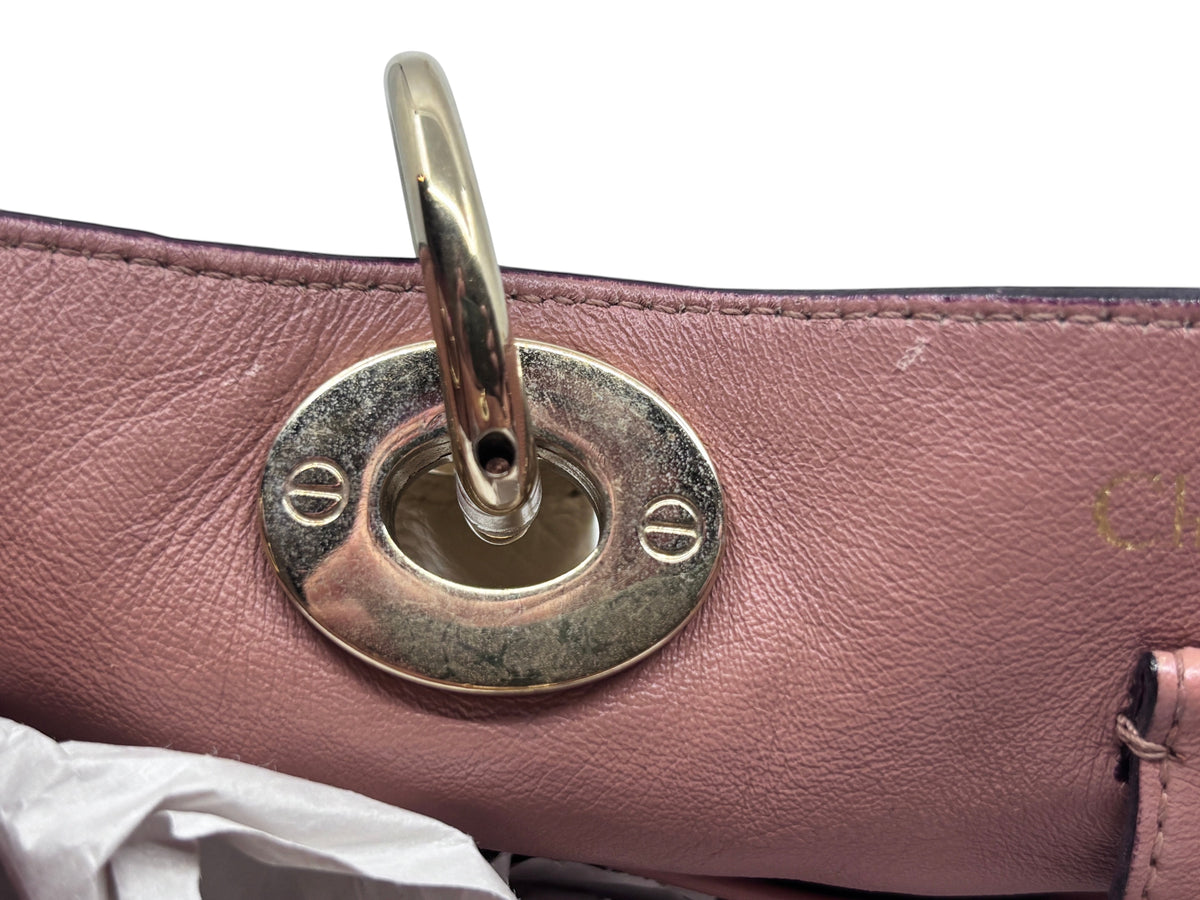 Close-up of polished gold-tone hardware on a tan leather Dior Diorissimo tote bag from Posh Purse Co.