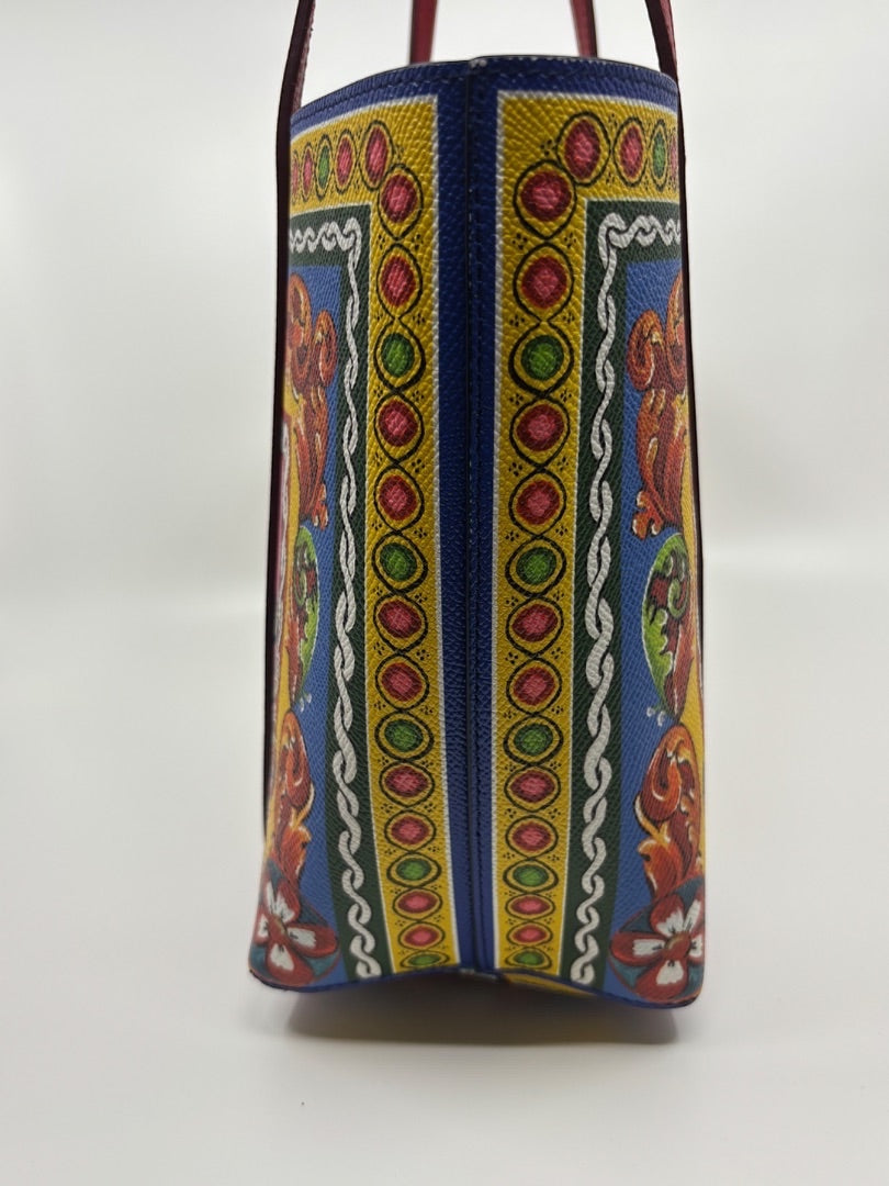 Posh Purse Co. Dolce & Gabbana Dauphine Escape tote bag with blue, yellow, red, and green ornate pattern. Leather trim and straps.