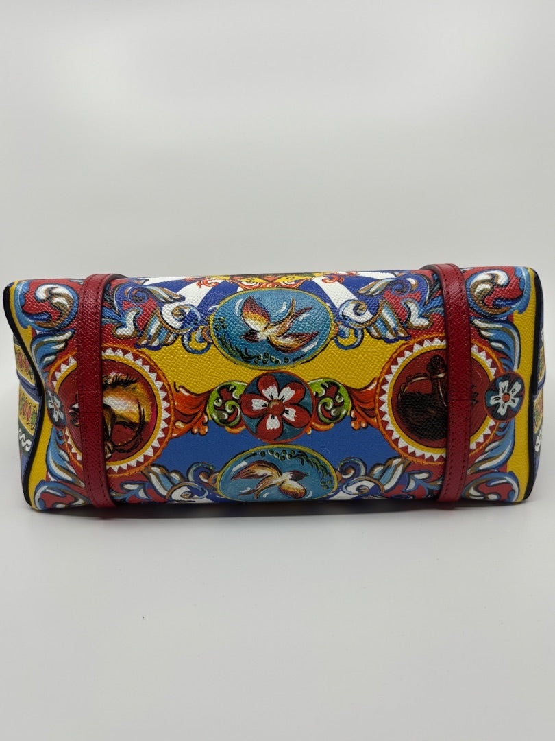 Dolce & Gabbana Dauphine Escape tote bag with a vibrant yellow, blue, and red print featuring birds and floral motifs. Red leather trim.