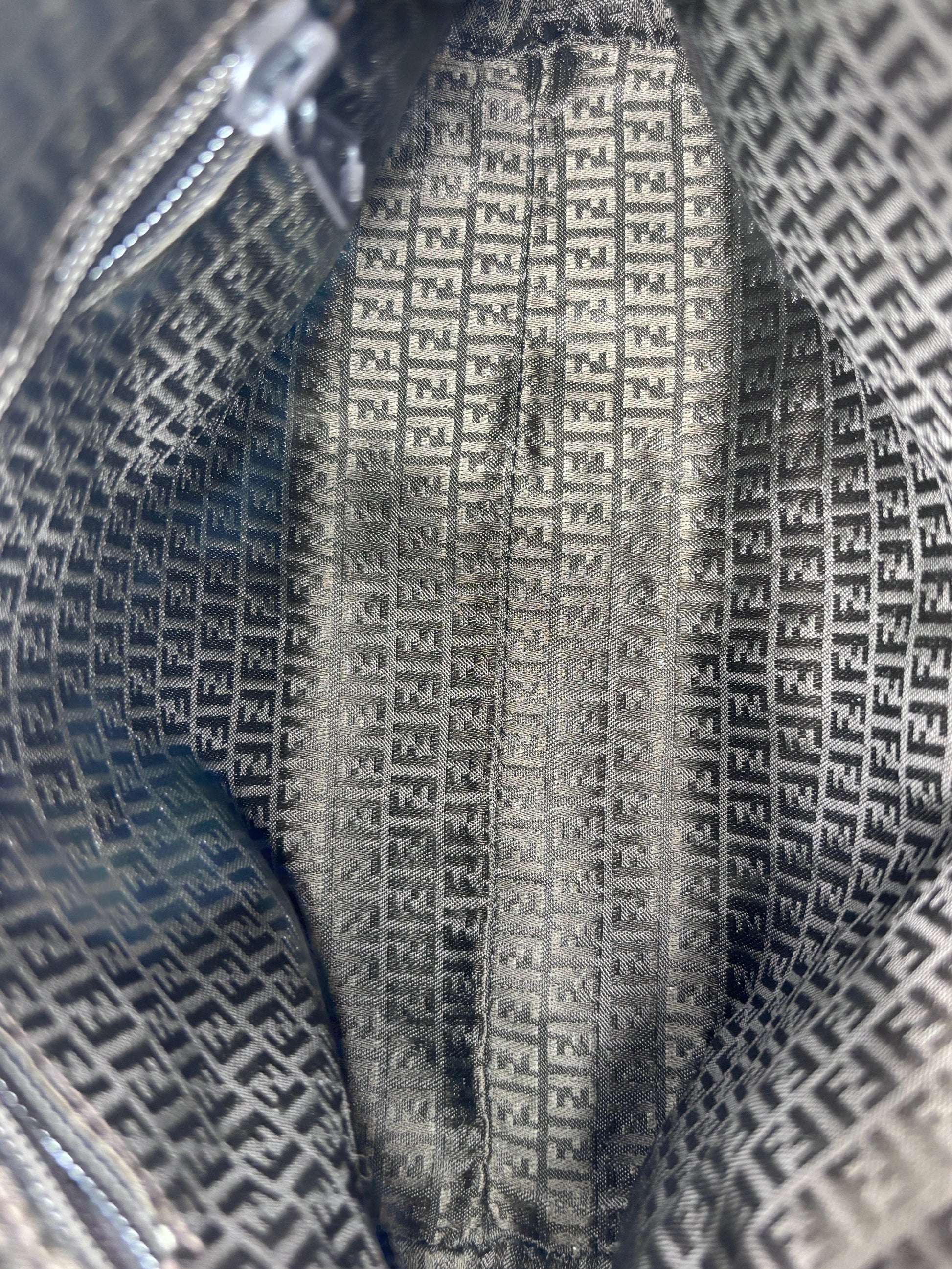 Interior lining of a Posh Purse Co vintage Fendi straw bag featuring the iconic black and grey Zucca logo pattern.