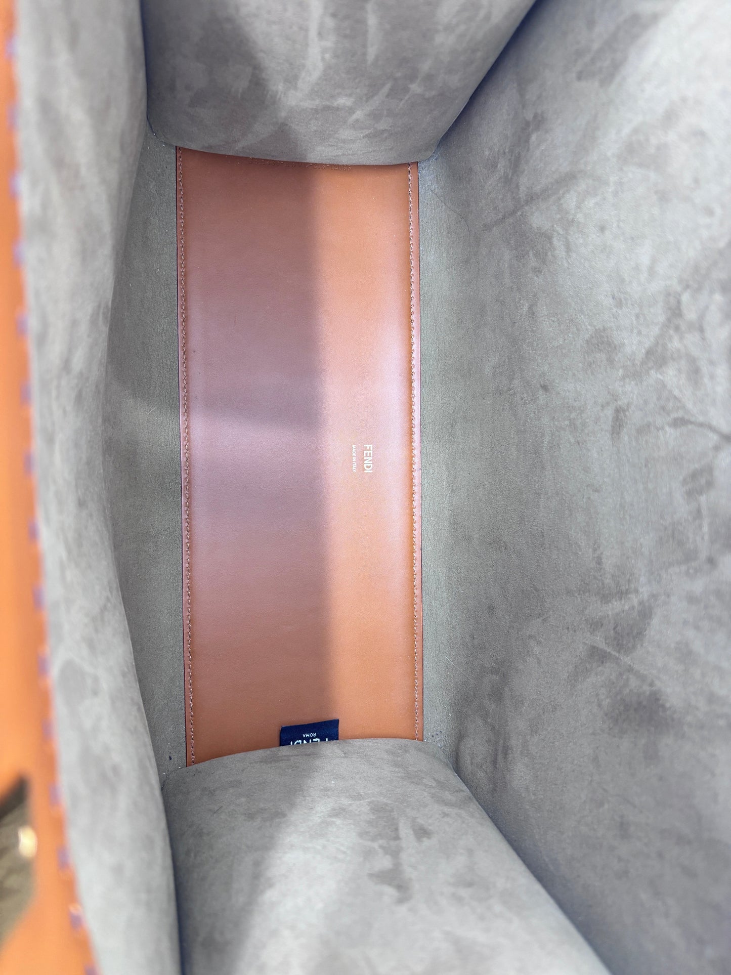 Interior view of a Posh Purse Co tan Fendi Sunshine bag showing the smooth leather base and grey suede lining