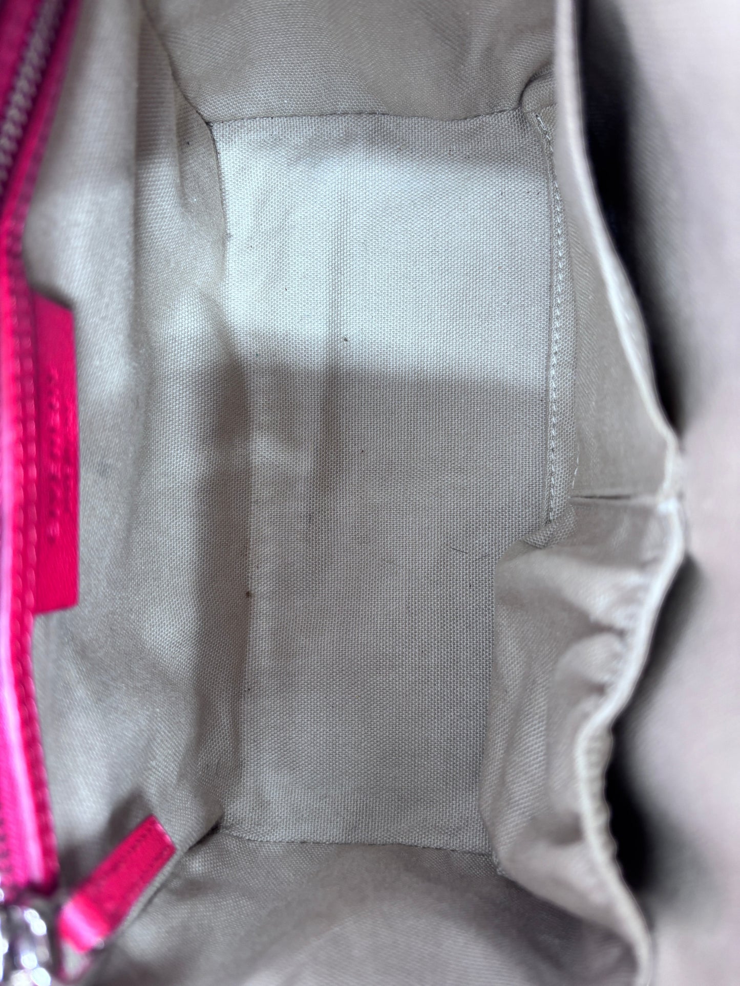Interior of Posh Purse Co red Givenchy Mini Antigona handbag featuring beige fabric lining and leather brand tag