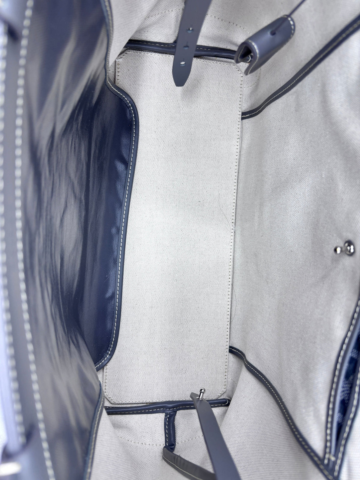 Interior view of a Posh Purse Co gray Goyard Bellechasse tote showing the spacious unlined canvas base and leather trim