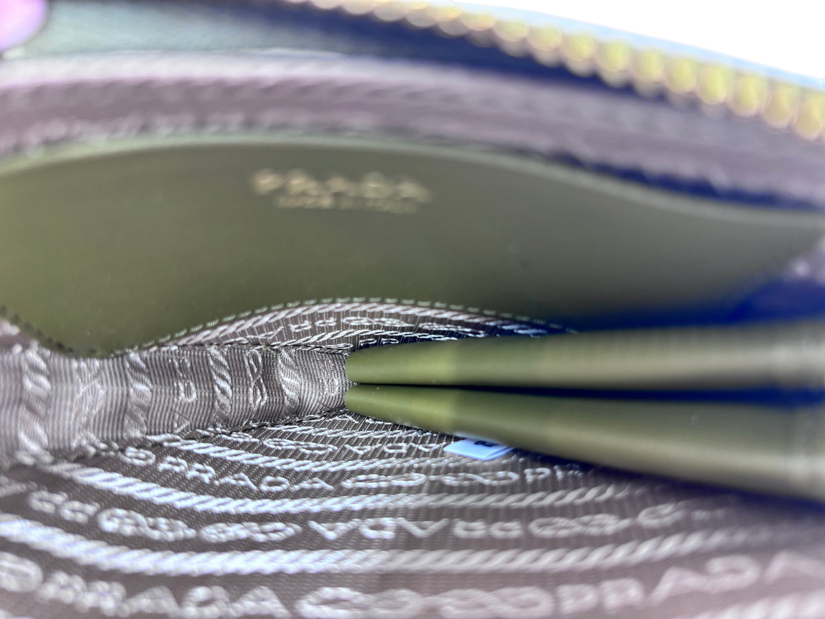 Interior of a Posh Purse Co green Prada mini triangle bag showing the signature Prada logo-patterned fabric lining.