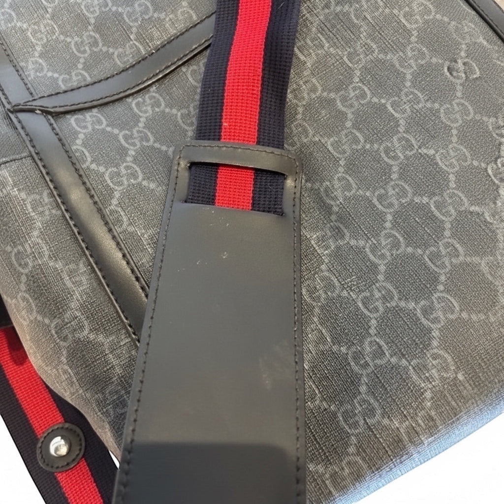 Posh Purse Co designer messenger bag in grey signature canvas with black leather trim and a red and blue striped adjustable strap.