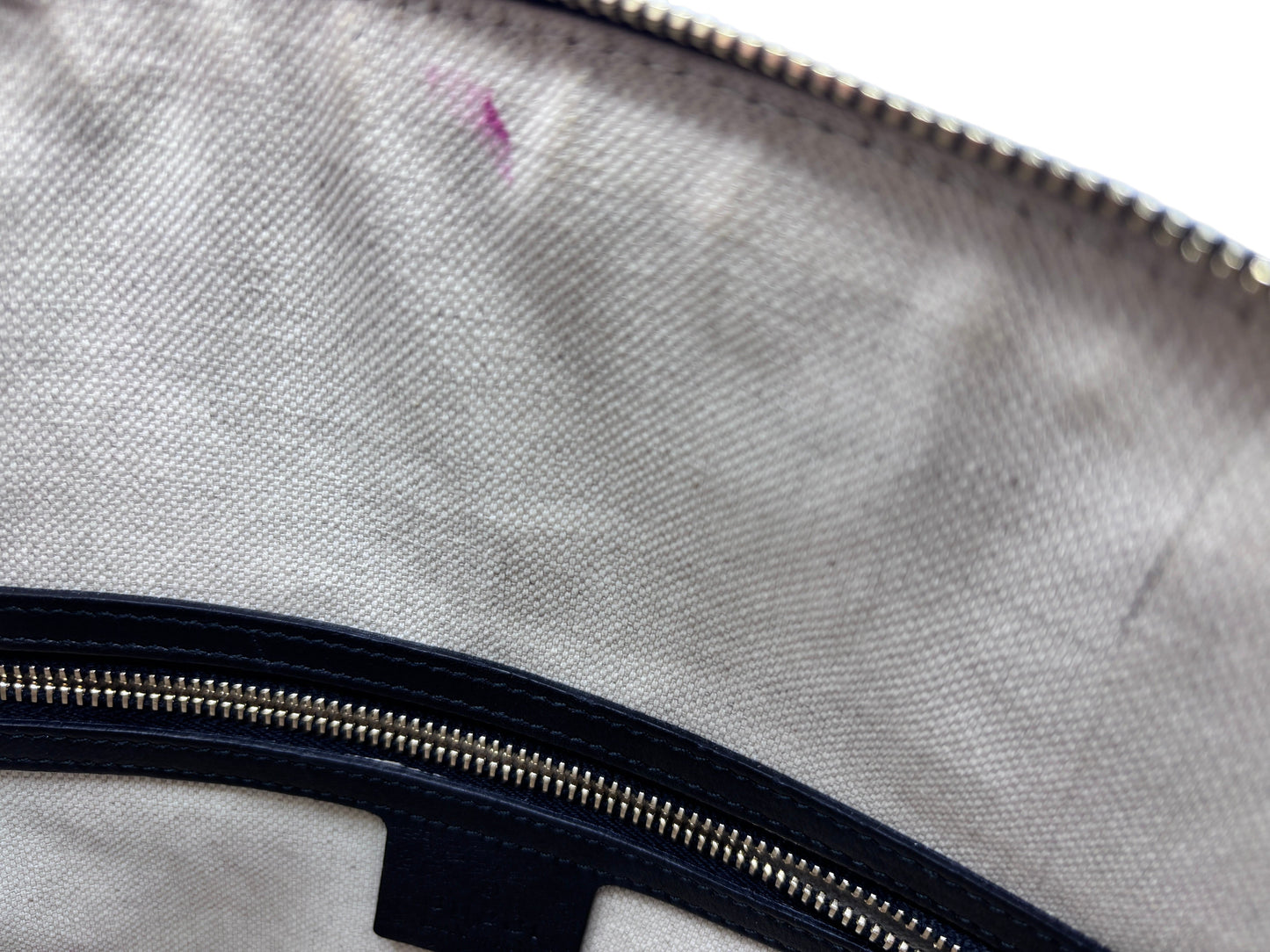 Interior lining of a Posh Purse Co preloved Gucci bag showing beige fabric with a visible pink pen mark near the zipper