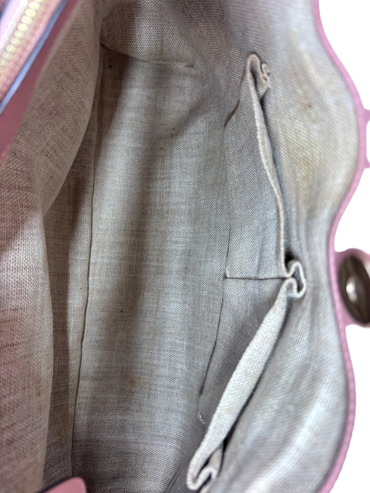Interior of Posh Purse Co pink Gucci Micro Guccissima bag showing light beige fabric lining with minor staining