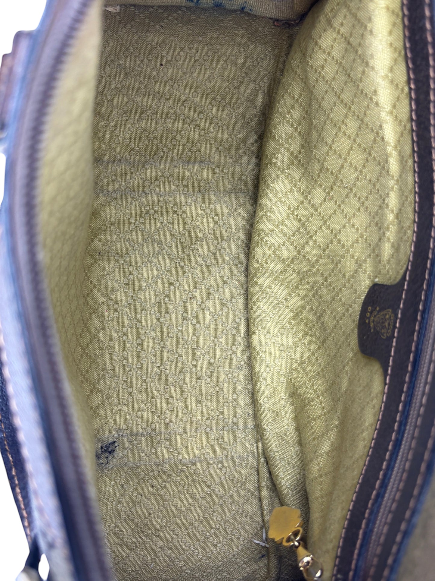 Interior of a vintage Posh Purse Co Gucci Boston bag featuring a beige diamond pattern lining and gold hardware.